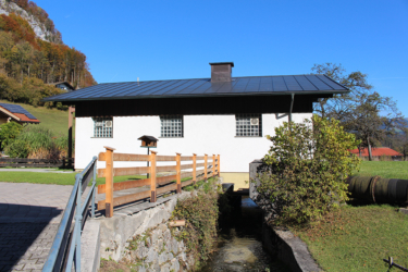 Blick auf das Gebäude des Wasserkraftwerks Oberaudorf mit Mühlbach